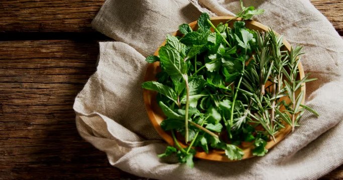 Fresh herbs in wooden plate 