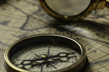 Retro compass with old map and magnifier