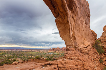 Storm clouds, rain, and red geologic sandstone structures in the Utah desert, Arches National Park