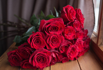bouquet of red roses on the windowsill