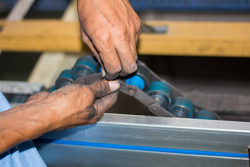 The technician repairing conveyor belt in factory