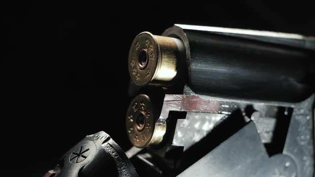 Smoke from the trunks of smooth-bore hunting rifle after firing. Slow motion. Black background.