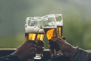 Foto auf Acrylglas Bier Bier mit Schaum helle große Jungen in den Händen von Freunden, die eine Toastnahaufnahme anheben