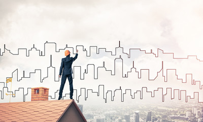 Man architect draw silhouette of modern city on blue sky. Mixed 