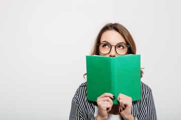 Portrait of a young casual girl holding opened book