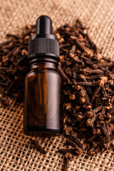essential oil of cloves on a wooden rustic background