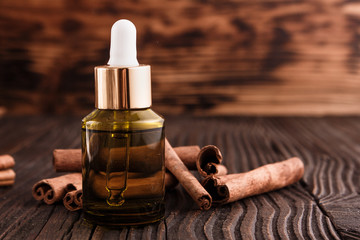 Obraz na płótnie Canvas Cinnamon essential oil on a wooden background