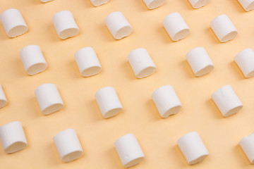 Sweet marshmallows on pastel yellow background.