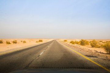 Desert highway and mountains through car window not far from Dead sea