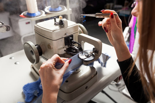 Close-up of a woman furrier working on a furrier's sewing machine to treat fur and skin
