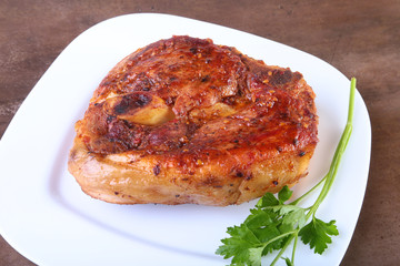 grilled pork chop with sauce on wooden table.