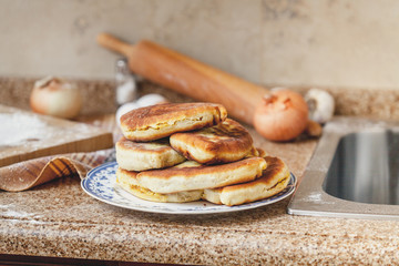 Plate with fried pies stands on marble table