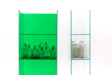 Vintage glass bottles on green showcase. Isolated on white background.
