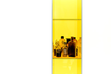 Brown vintage glass bottles on yellow showcase. Isolated on white background.
