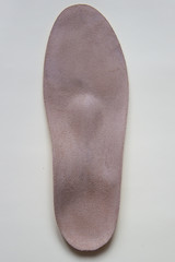 Leather orthopedic insole for footwear on beige background