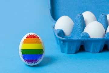 Conflict of society with LGBT people. One egg is colored in the flag of LGBT