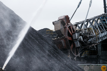 NAKHODKA, RUSSIA - CIRCA AUGUST, 2017: Coal heaps, spraying of coal piles with water, coal dust