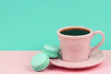Pink cup of coffee with macaroons on pastel blue pink background. copy space
