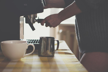 Beautiful nude sexy girl in the sweater makes coffee at home. 