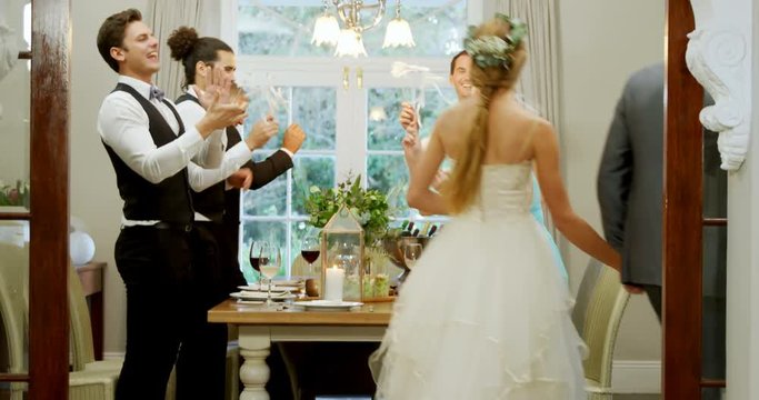 Bride and groom walking hand in hand while guests applauding  