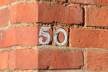 House number 50 sign painted white on wall