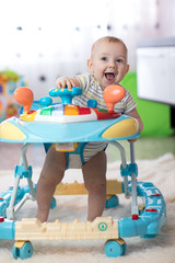 cheerful baby in the baby walker in living room