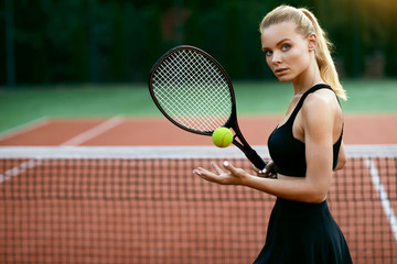 Woman Playing Tennis On Court.