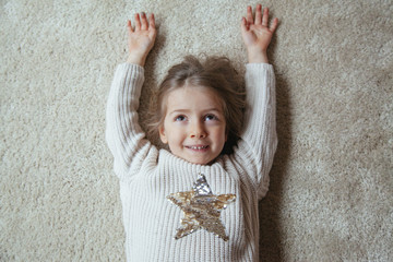 little blonde kid smiling with a star on her sweater