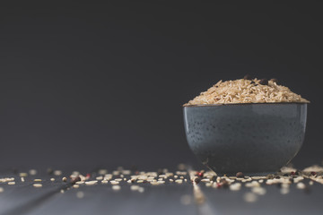 bowl of raw rice on black table with copy space