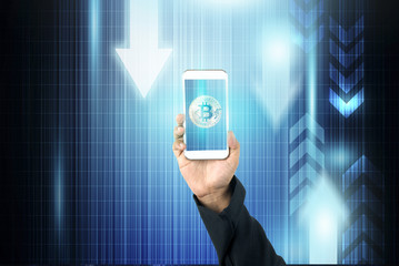Hand holding mobile phone with bitcoin on blue technology background