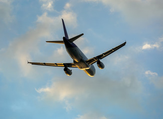 Airplane in clouds at sunset
