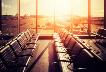 Empty seats in an airport departure hall at sunset, color toned picture, travel and transportation...