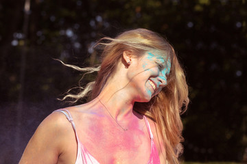 Closeup portrait of positive young woman with wind in hair posing on Holi festival