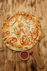 Vegetarian pizza on wooden board served with ketchup