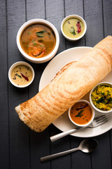 Masala dosa with chutney and sambar and potato sabzi. Cone, triangle or roll shape, selective focus
