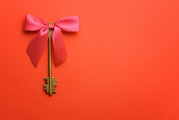 Vintage keys with pink bow over red background