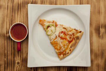 a piece of vegetarian pizza on a plate served with ketchup