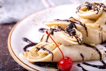 Pancakes with chocolate sauce and cherrie