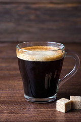 black coffee in a glass mug on a wooden table