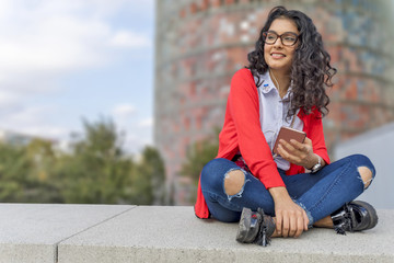 A young woman listening music on digital tablet sitting