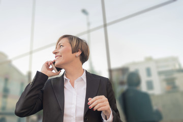 Executive talking on phone looking at camera on the street