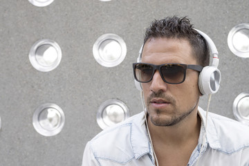 Portrait of a young man listening music with earphones