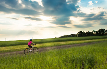 girl on a bicycle in rural landscape