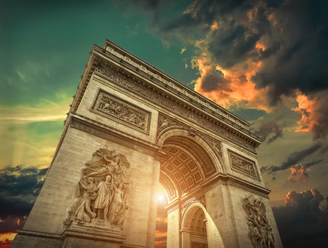 Arc de Triomphe in Paris under sky with clouds. One of symbols o