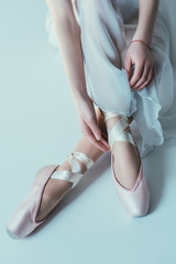 low section view of elegant ballerina in white dress and ballet shoes