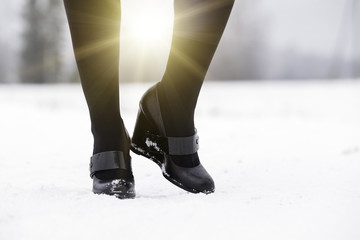 female legs in fashionable leather black boots.