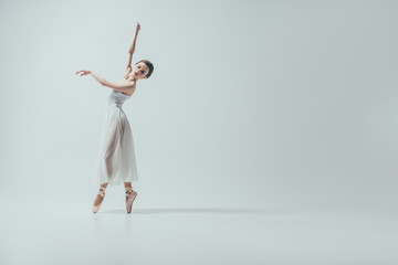 attractive ballerina in white dress dancing in studio, isolated on white - obrazy, fototapety, plakaty