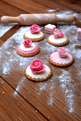Cakes with mastic, flour, marshmallow, wooden background. Easter cakes.