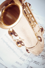 Part of saxophone lying on the notes