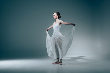 elegant ballerina standing in white dress